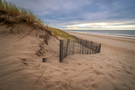 Wooden fence on sandy beach dune with ocean viewの写真素材