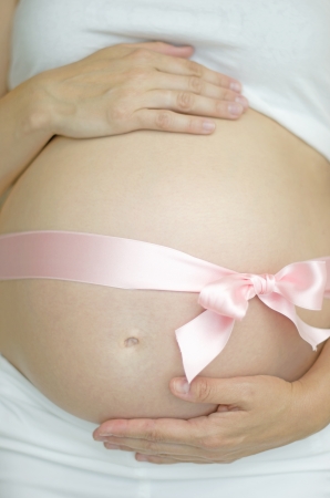 Pregnant woman with a pink ribbonの写真素材