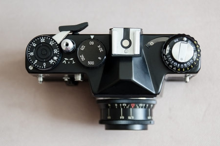 Old black vintage camera on brown background