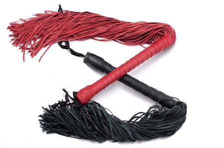 Black and red crossed sex erotic leather whips on white backgroundの写真素材