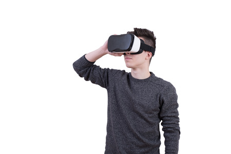 The man with glasses of virtual reality on white isolated background. Young guy in VR headset is looking at interactive screen. Playing mobile game app on device.の写真素材