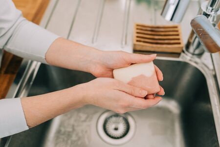 Hygiene to stop spreading coronavirus. Woman washing hands rubbing with soap in sink in kitchen. WHO technique cleaning hands with soap according for coronavirus prevention.の写真素材