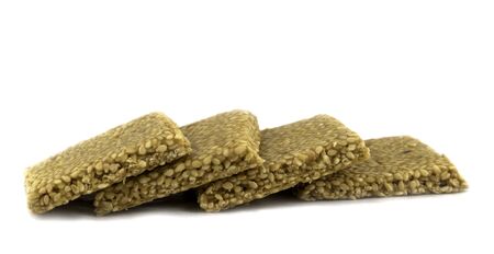 Til chikki on white background is an Indian sweet dish made with jaggery and sesame seedsの写真素材