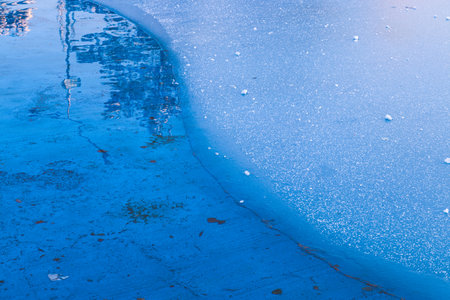 Snowflakes on frozen water, ice blue background.の写真素材