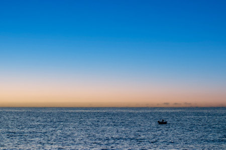 Fishing Journey on a Boat at Sunset. Dramatic Scene. Background Image with Text Area.Trabzon, Turkeyの写真素材