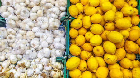 Overhead view of garlic and lemons in a market display, representing flavor and natural health.の写真素材