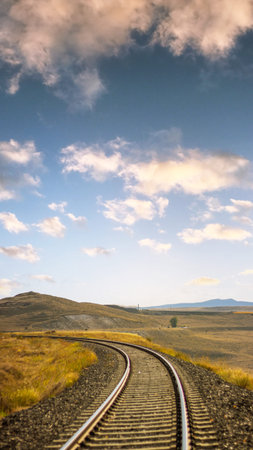 Vertical railway track with scenic sky, perfect for wallpaper or background use, symbolizing...