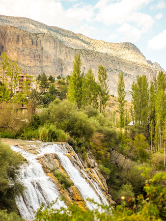 Tortum Selalesi or Tortum Waterfall with lush greenery, cascading waters, and towering cliffs, symbolizing nature's powerの写真素材