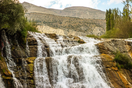 Tortum Selalesi or Tortum Waterfall with lush greenery, cascading waters, and towering cliffs,...