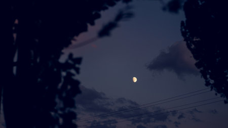 Dark night sky with glowing moon, perfect for wallpaper and background designs.の写真素材