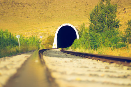 Railroad tunnel and tracks leading into the unknown, scenic perspective.の写真素材
