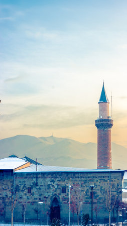 Erzurum Ulu Mosque minaret with the snowy Palandoken Mountain in the background.の写真素材