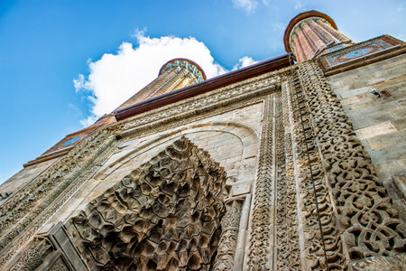 A stunning view of the ornate carvings and twin minarets of Erzurum Twin Madrasa, showcasing the intricate Seljuk architectural craftsmanship.の写真素材