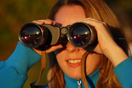 girl with binoculars looking at the landscapeの写真素材