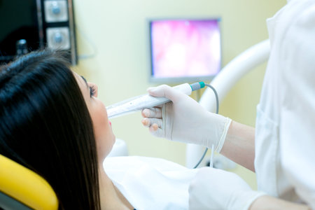 young women to the dentist in the dental chair sits next to a doctor to do the dentist to see if his teeth were okayの写真素材