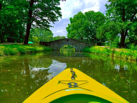 Canoeing on the river in the park with a bridge in the backgroundの写真素材