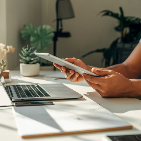 Cropped image of businessman using digital tablet while sitting at office deskの素材