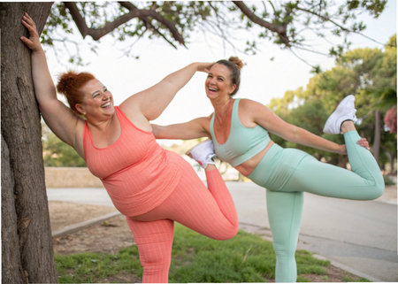 Portrait of happy mother and daughter doing yoga together in the parkの素材
