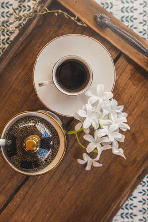 Arabic Lebanese black coffee cup on wooden tray with flower plant | Top view shotの写真素材