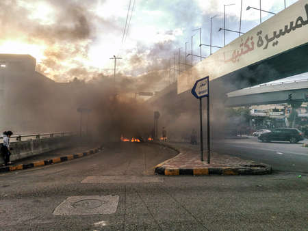 Lebanese Protesters Burning Tires on Airport Highway Ghobeiry Beirut suburb / Dahye cutting the Road in objection against the Economical Crisis and Lebanese Pound Value dropのeditorial素材