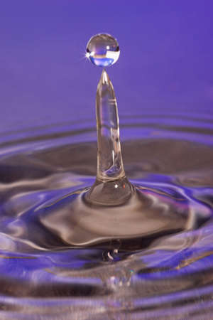 Closeup of an water-column, after a drop hits the surface. Maybe you can see on photo a balancing abstract. Object was very close to optic, that's why DOF is narrow. Photo was taken with 3 flashes, ISO 100, RAW. Focus was at the bottom of the water columnの写真素材