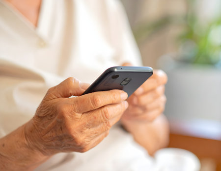 Elderly woman using smart phone at home, selective focus.の写真素材
