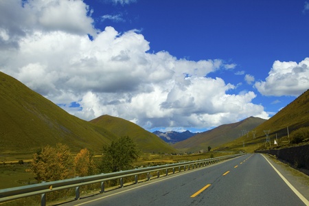 The long curving montanic road in Tibetan plateau summer, Chinaの写真素材