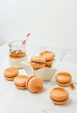 orange macarons with milk on a white wooden table. verticalの写真素材