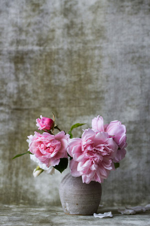 Pink roses in a vase on a wooden background. Selective focus.の写真素材