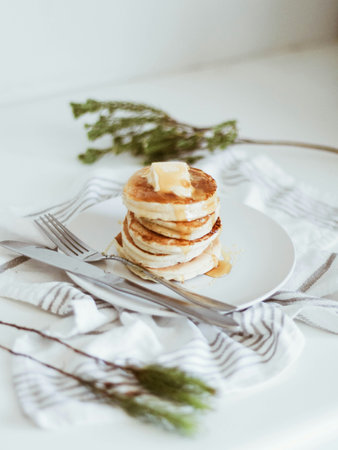 Pancakes with butter and honey on a white plate, selective focusの写真素材