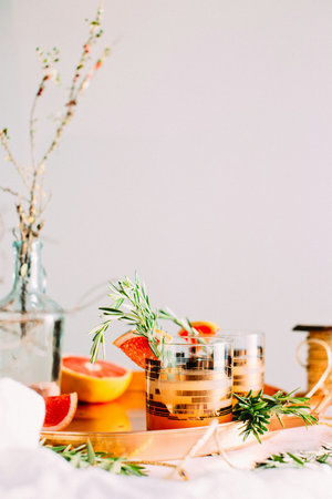 Two glasses of wine with orange and rosemary on a white backgroundの写真素材