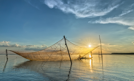 Dong Nai, Vietnam - November 15th, 2015: The Fishermen are mending nets as patch Implied HIS life in autumn afternoon in Tri An, Dong Nai, Vietnamのeditorial素材