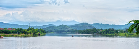Hue, Vietnam - June 21st, 2015: A small boat on the river to turn lonely shivering ripples, the mountains and the clouds away is to make real peace of the countryside scenery in Hue, Vietnamのeditorial素材