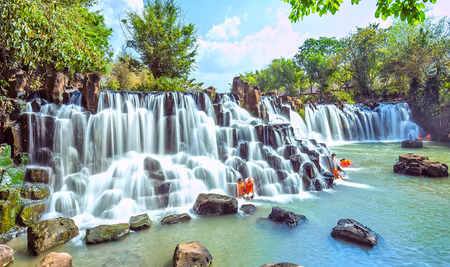 Dong Nai, Vietnam - March 1st, 2015: Waterfall with water flowing Into early sunshine as an arc ladder white silk sheet on cliffs Attract tourists in bathing, relaxation holidays in Dong Nai, Vietnamのeditorial素材
