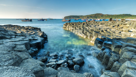 Exposure Giant's Causeway waves at dawn, fishing boats are still awake. Giant's Causeway is the...