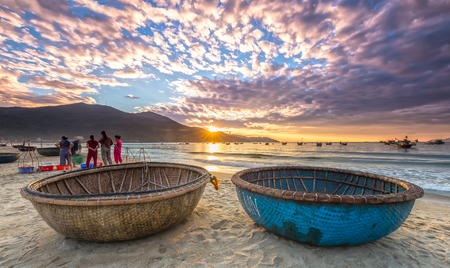 Da Nang, Vietnam, June 26, 2015: Sunrise over seaside with sunlight to create stars and double Pannier foreground boat, exercising and watching ng??i Fishermen bring fish on sale in Da Nang, Vietnamのeditorial素材