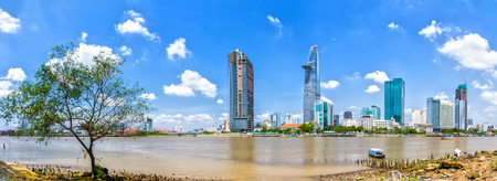 Ho Chi Minh City, Vietnam - April 1st, 2014: A boat Towards the river bank where the skyscrapers typical image is renewed Saigon in Ho Chi Minh City, Vietnamのeditorial素材