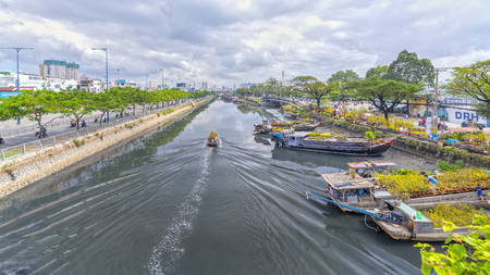 Ho Chi Minh City, Vietnam - January 26th, 2017: Boating along canal with apricot carry flowers, confetti, almond treeのeditorial素材