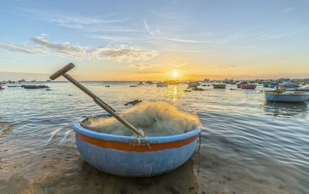 Sunset and boat on the sea as the sun slowly down the horizon circle creates a beautiful golden light on the bay. It's great to idyllic scenery here.の写真素材