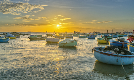 Sunset and boat on the sea as the sun slowly down the horizon circle creates a beautiful golden light on the bay. It's great to idyllic scenery here.の写真素材