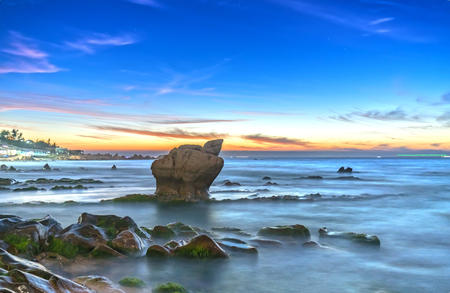 Dawn on ancient rocks moss covered with colorful sky welcome beautiful new day on the bayの写真素材