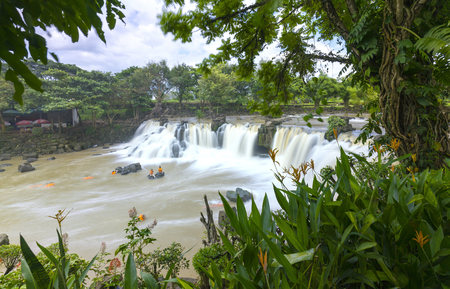 Beautiful waterfalls in Ecotourism with water flowing smooth as silk attract tourists to visit on a sunny summer dayの写真素材