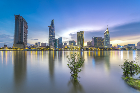 Ho Chi Minh City, Vietnam - June 15th, 2017: Riverside City sunrays clouds in the sky at the end of the day brighter coal sparkling skyscrapers along the beautiful river in Ho Chi Minh City, Vietnamのeditorial素材