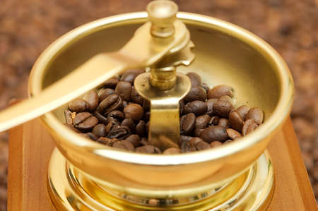 Old brown coffee-grinder with coffee beansの写真素材