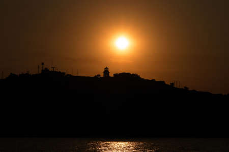 Sunset on Black Sea in Crimea and lighthouse on mountain                     の写真素材