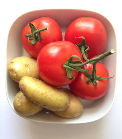 Tomatoes and potatoes in a bowlの素材