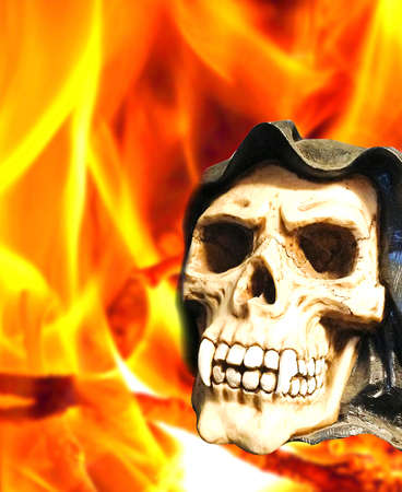 horror skull with canine teeth on fire backgroundの写真素材