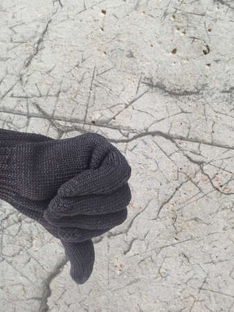 thumb down finger sign for reject symbol on defected concrete panel background or textureの写真素材