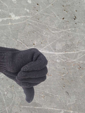 thumb down finger sign for reject symbol on defected concrete panel background or textureの写真素材