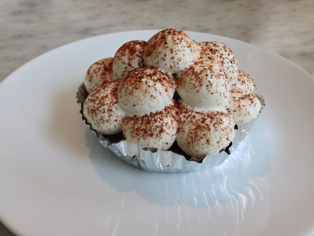 piece of banoffee cake with chocolate powder on white plateの写真素材